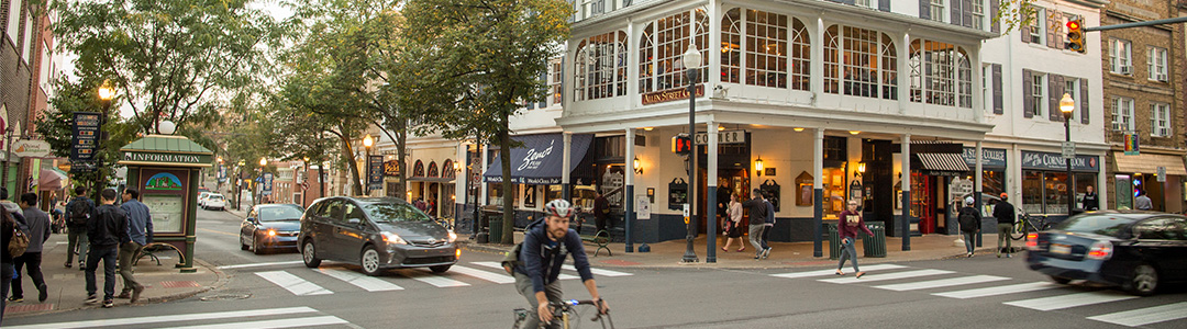 Person riding a bike in front of buildings