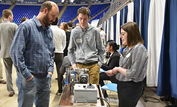 student explains project at showcase