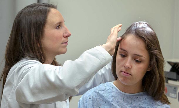 dermatology resident examining a patient