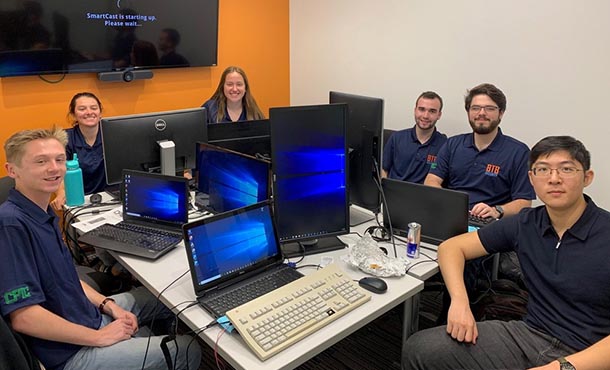 penn state team members seated at tables with their laptops