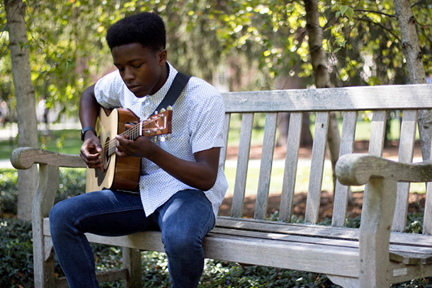 African American male playing a guitar