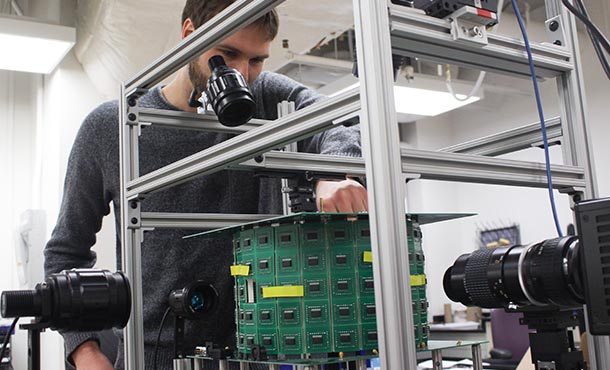 a man stands in front of a tabletop virtual reality simulator for flying insects