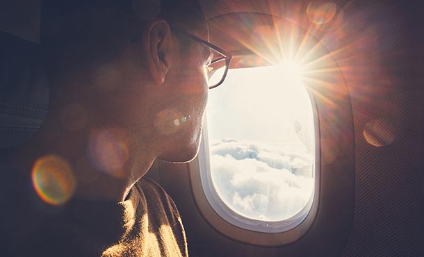 man looking out of airplane window