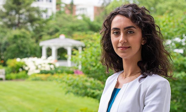 Melika Sharifironizi standing casually outdoors near the Alumni Building garden.