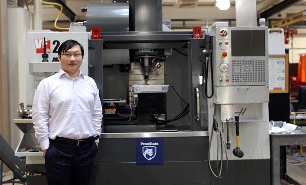 Hongtao Sun standing in front of a machine in the laboratory