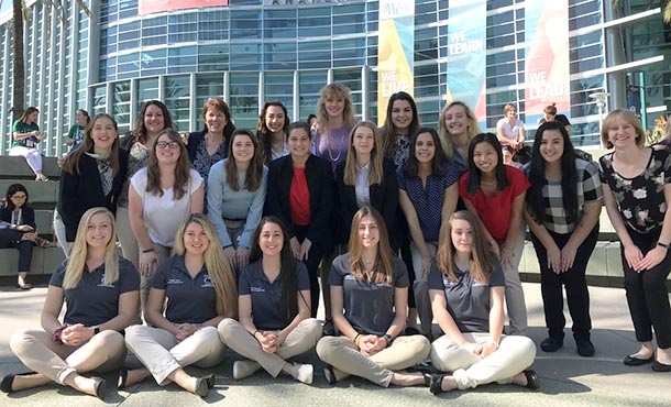 group of female students pose outside a convention center