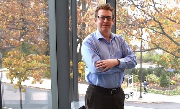 Man standing in front of window with arms crossed