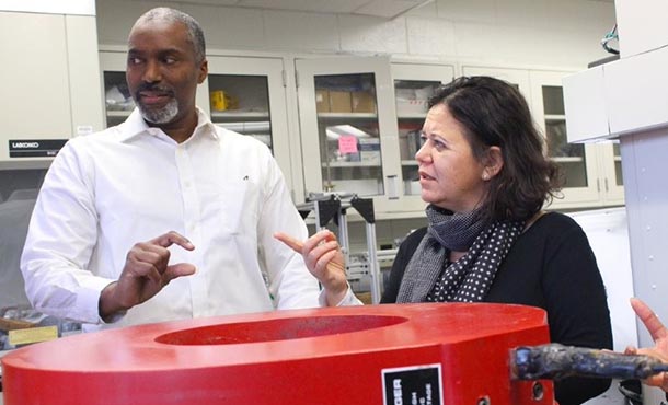 a man and a woman stand in front of a large magnet